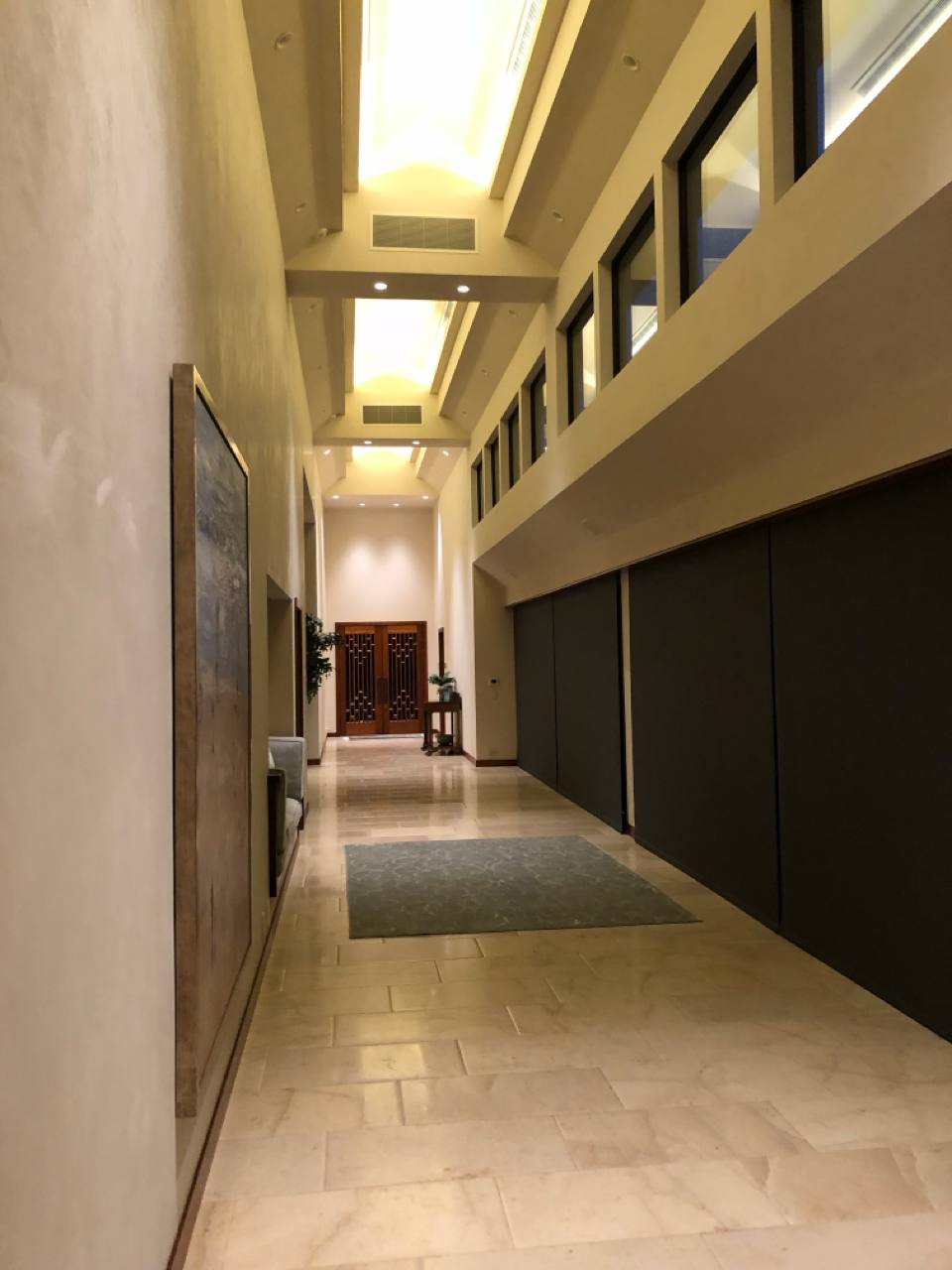 Grand hallway — recessed lighting, skylights, ornate lattice doors, stone tile
