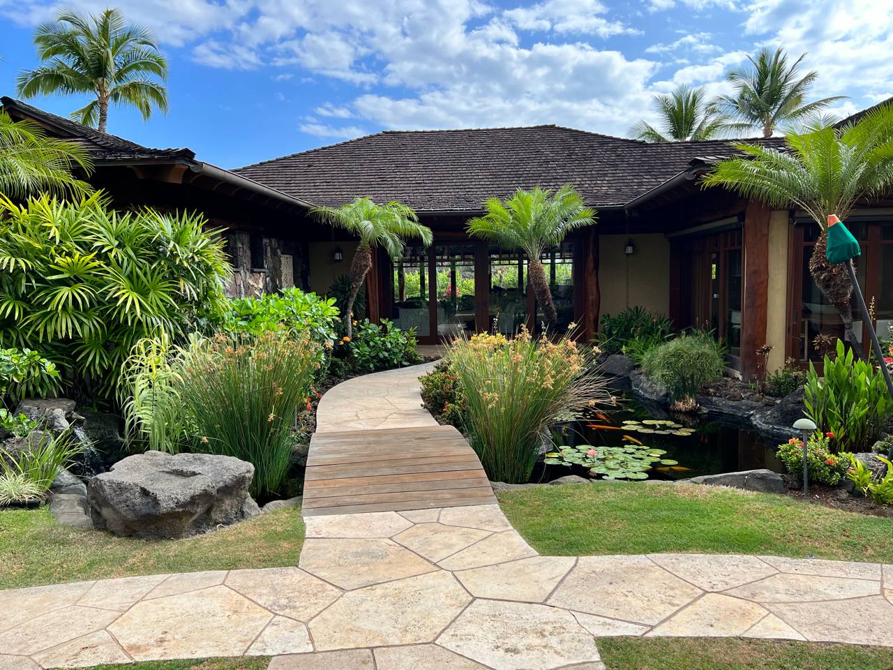 Estate entrance — koi pond, boardwalk, lava boulders