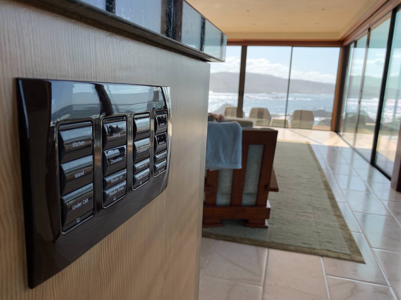 Lutron keypad — Kitchen, Island, Shades Up/Down buttons, coastal ocean view behind