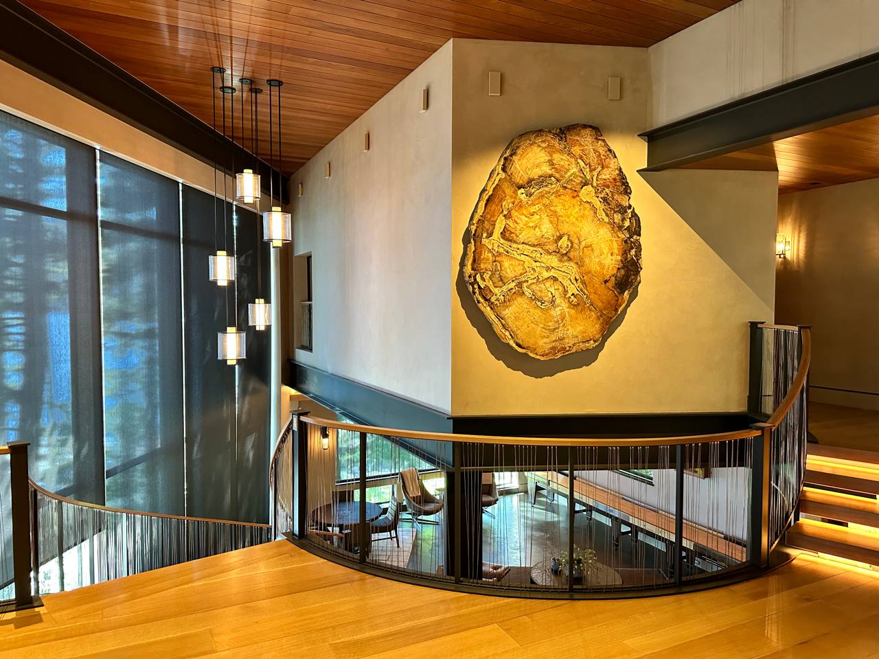 McCall Idaho — double-height atrium, petrified wood art, cascading pendants, curved staircase