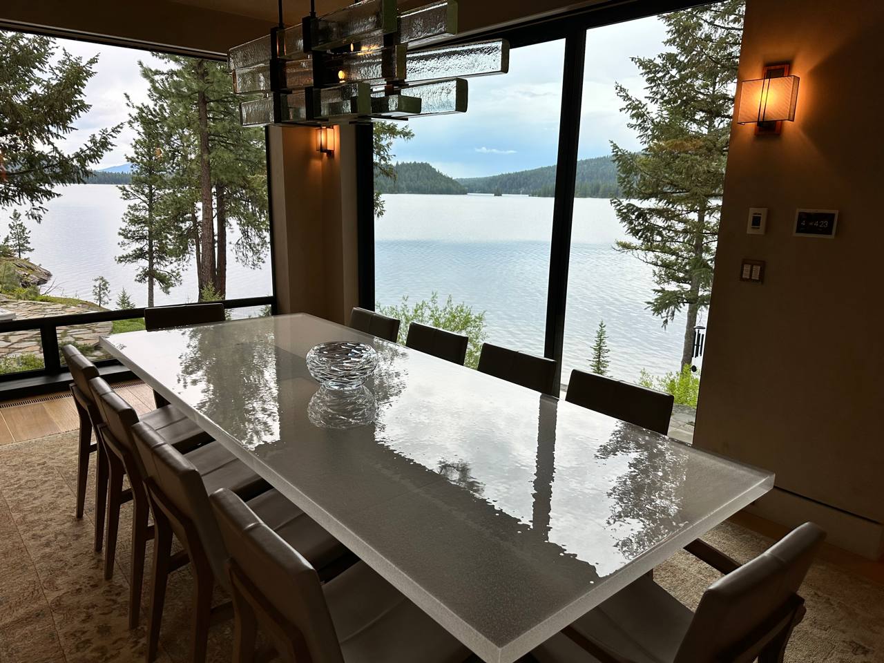 McCall Idaho — 10-seat dining, reflective table mirroring lake, glass chandelier, pine hills