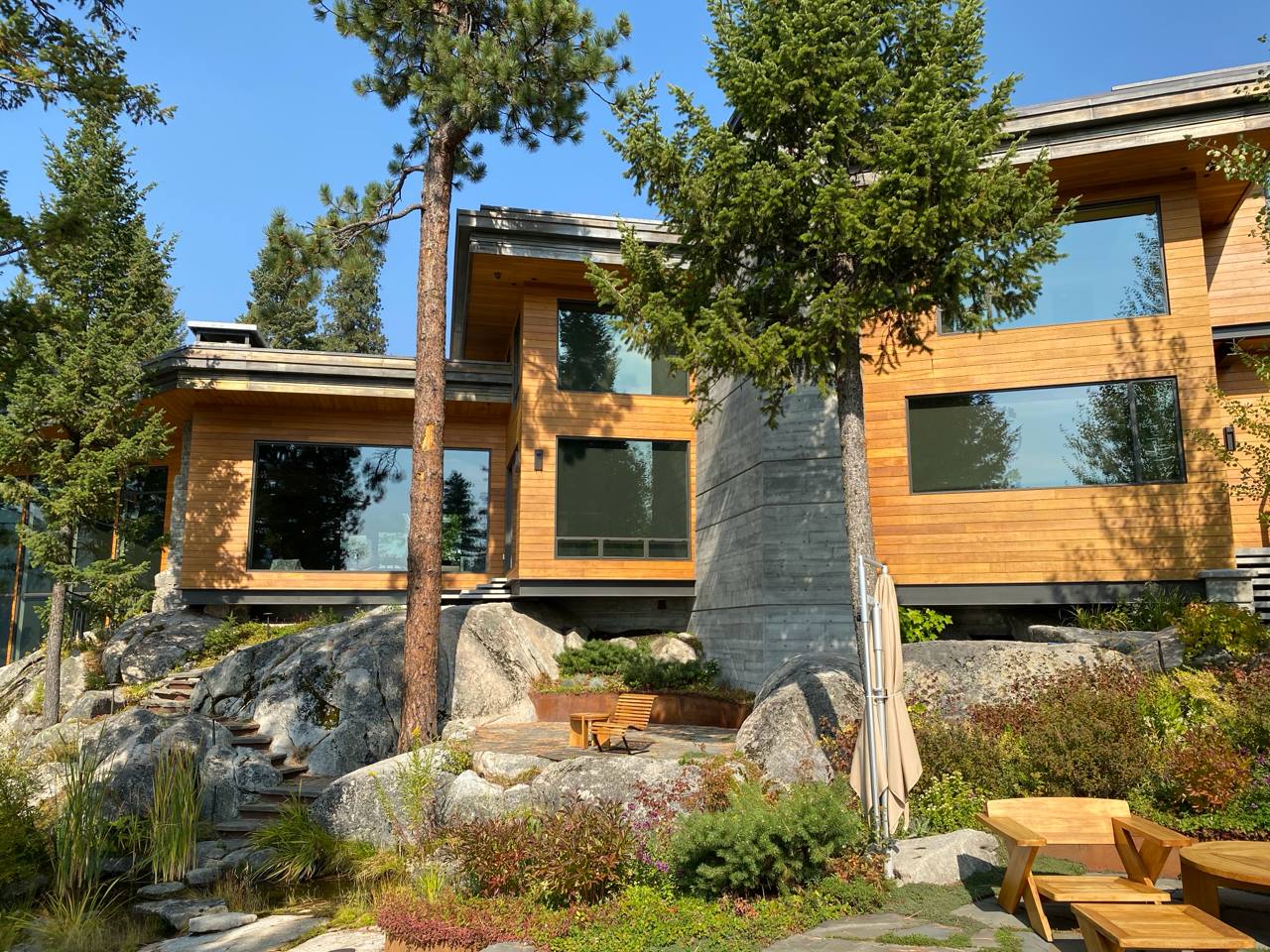 McCall Idaho — multi-level cedar home on boulder hillside, pines, stone steps, lounge area
