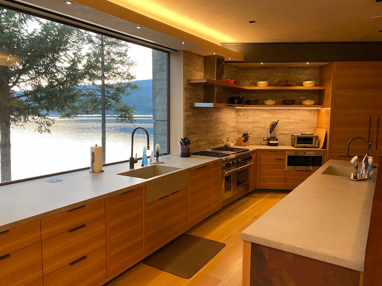 McCall Idaho — wood kitchen, concrete counters, LED ceiling, lake through panoramic window