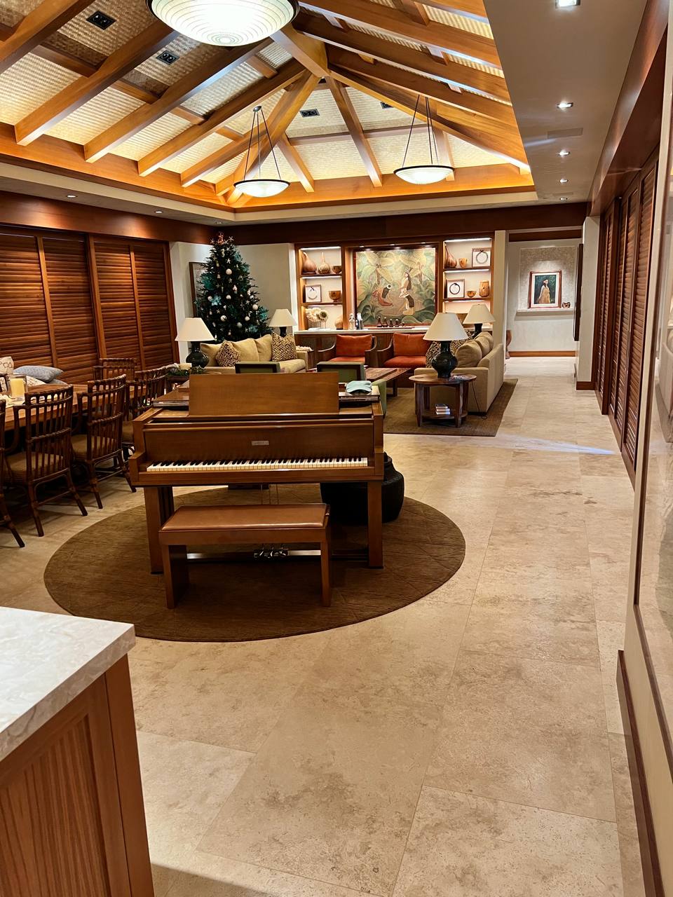 Resort lobby — vaulted koa beams, piano, pendant lights, warm Lutron scenes