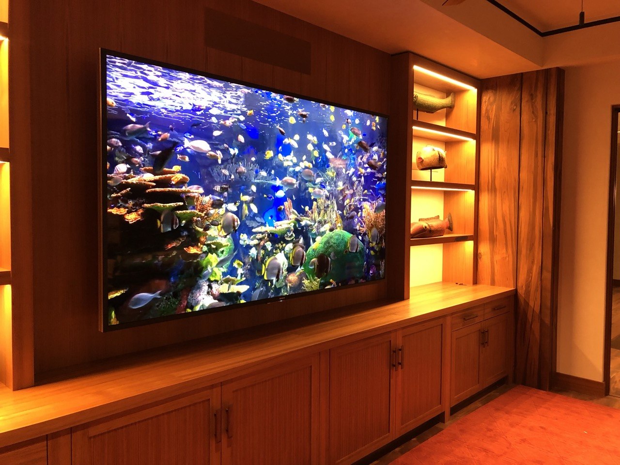 Built-in entertainment center — large display, wood paneling, accent lighting